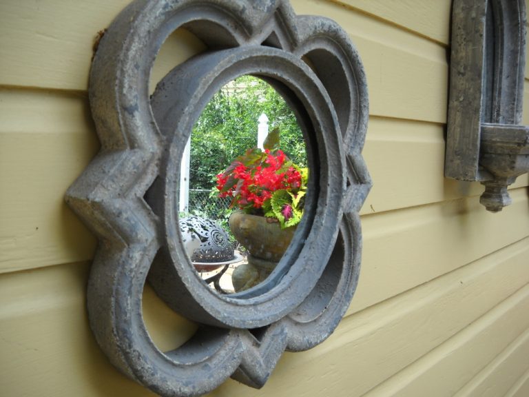 Mirror reflecting container planting of geranium and coleus