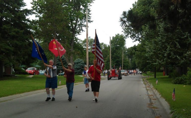 Three men bear flags at the head of the ECCO 4th of July Parade 2011