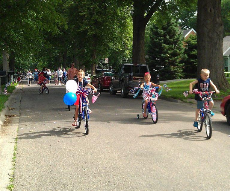 Two girls and a boy ride their bikes at the head of the ECCO 4th of July Parade 2011