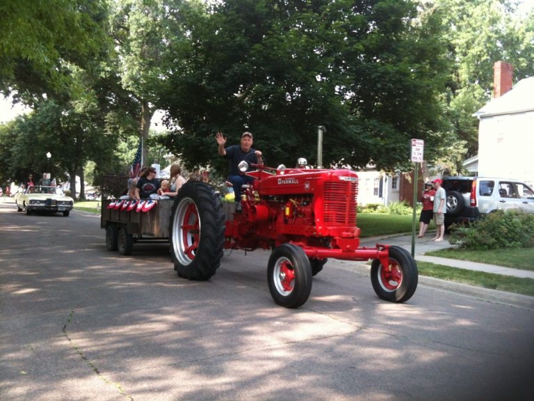 Red farmall tractor pulls trailer decorated for ECCO 4th of July Parade 2015