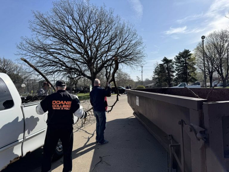 Tossing refuse into a dumpster at 2025 Spring Clean-up event (Photo courtesy of Lora Black)