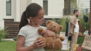 portrait-of-cute-little-girl-with-plush-bear-posing-for-camera-in-front-yard